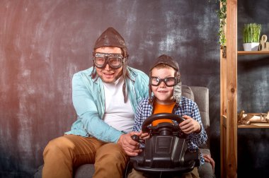 Video oyun kontrolörleri olan bir adam ve küçük bir çocuk. Baba ve oğul. Çocuk ve babası geçmişe dönük.