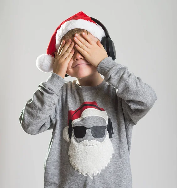 穿着圣诞礼帽和毛衣的有趣的小男孩用手闭上眼睛 笑脸等待惊喜 孩子们梦想着新年礼物和礼物 奇迹与盲信概念 — 图库照片