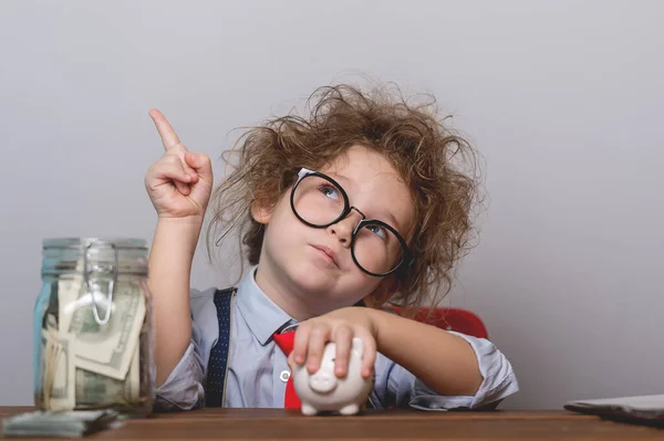 Små barn flicka räkna mynt för att räkna ut hur mycket pengar hon har sparat för framtiden och utbildning. Tillbaka till skolan — Stockfoto