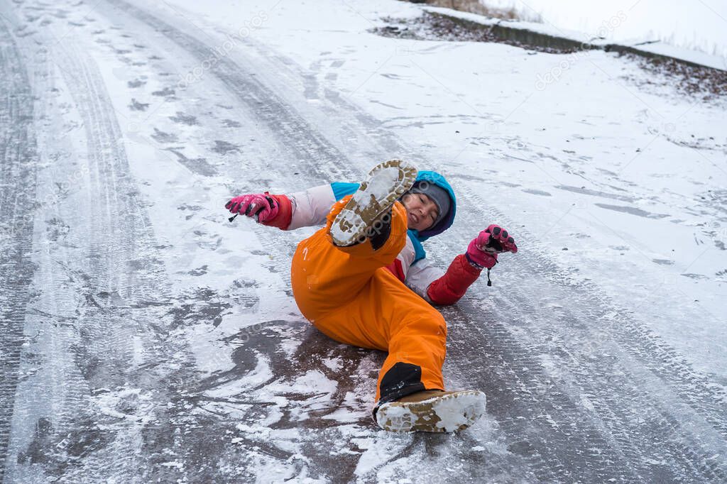 Woman is lying on a icy on road. Fall down because of slippery way. People can brake hand or leg