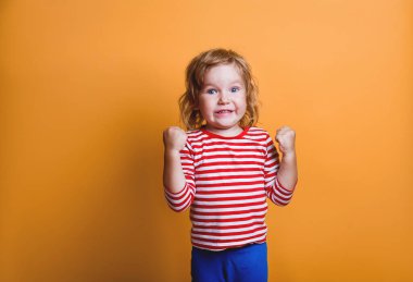 Komik bir çocuğun zaferi kendinden emin bir şekilde kutlamasının portresi. Şanslı kız sarıda izole edilmiş. Kazanan çocuk, evet elli. Çizgili tişörtlü güçlü lider bebek.