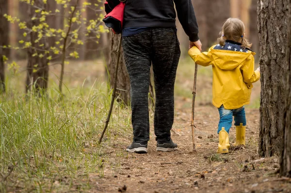 Baba ve kızı gün batımında ormanda yürüyüş yaparken. Sürdürülebilir doğa.