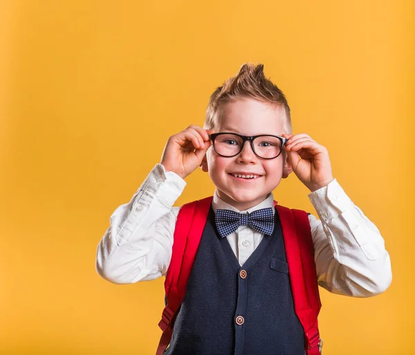 Estudante elegante em óculos com saco. Retrato de rapaz. Rosto de criança loira sorridente isolado em amarelo. De volta à escola. — Fotografia de Stock