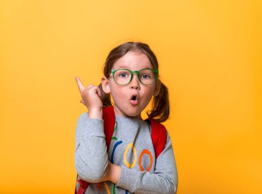 Little girl has and idea. Back to school. Kid pointing finger up. Nerd child in glasses. Pupil expert. News and innovation in education.