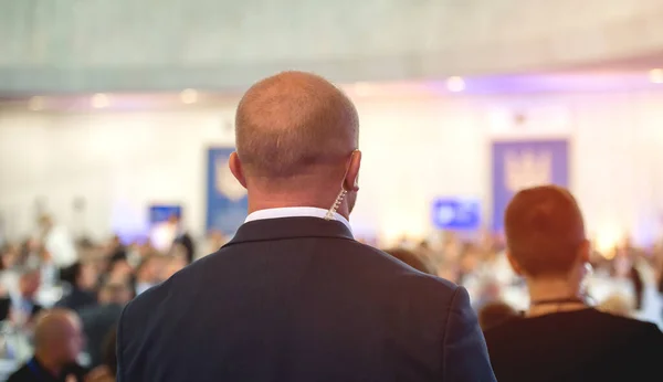 Güvenlik görevlisi halka açık bir toplantıda. Olgun güvenlik görevlisi kalabalığa karşı kulaklık dinliyor. Gizli servis ajanı kulaklığını dinliyor. Gizli Servis Ajanı