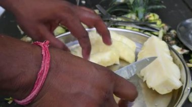 Pineapple or Ananas comosus chopping with knife. It is atropical plantwith an edible fruit. It is plant in the familyBromeliaceae. Fruits cutting. 