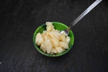 Siyah arka planda ananas ya da ananas parçaları. Yenilebilir meyvesi olan atropik bir bitki. Bromeliaceae familyasından bir bitki. Ananas parçaları kasede yemeye hazır..