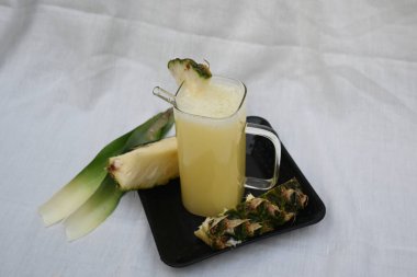 Beyaz arka planda ananas suyu. Taze ananas suyu ve ananas parçalarıyla dolu bir bardak. Sağlıklı meyve suyu. Ananas suyu..