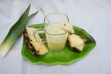 Beyaz arka planda ananas suyu. Taze ananas suyu ve ananas parçalarıyla dolu bir bardak. Sağlıklı meyve suyu. Ananas suyu..