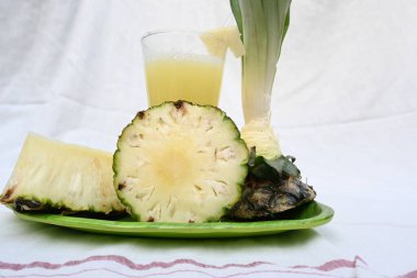 Beyaz arka planda ananas suyu. Taze ananas suyu ve ananas parçalarıyla dolu bir bardak. Sağlıklı meyve suyu. Ananas suyu..