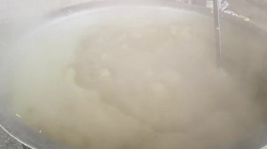 Büyük metal bir tencere khichdi pişiriyor. Kömür ocağında kırsal bir ortamda pişirilen geleneksel, yaygın bir yemek. Pirinç, nabız, sebze ve baharat karıştırılarak yapılır. Geleneksel Hint yemekleri.