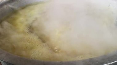 Büyük metal bir tencere khichdi pişiriyor. Kömür ocağında kırsal bir ortamda pişirilen geleneksel, yaygın bir yemek. Pirinç, nabız, sebze ve baharat karıştırılarak yapılır. Geleneksel Hint yemekleri.