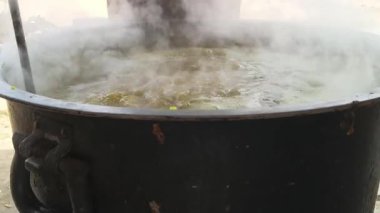 Büyük metal bir tencere khichdi pişiriyor. Kömür ocağında kırsal bir ortamda pişirilen geleneksel, yaygın bir yemek. Pirinç, nabız, sebze ve baharat karıştırılarak yapılır. Geleneksel Hint yemekleri.