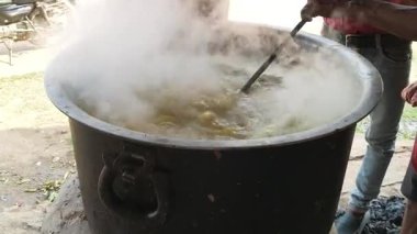 Büyük metal bir tencere khichdi pişiriyor. Kömür ocağında kırsal bir ortamda pişirilen geleneksel, yaygın bir yemek. Pirinç, nabız, sebze ve baharat karıştırılarak yapılır. Geleneksel Hint yemekleri.