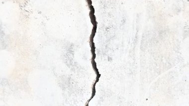 Çimento duvarında bir çatlak ortaya çıktı. Bu çatlak, yapının hafif toprak üzerine inşa edildiği, yağmur mevsiminde toprak aşındığı ve duvarın çatlamasına neden olduğu için meydana gelir. Bu da inşaat alanında hasar olduğunu gösterir..