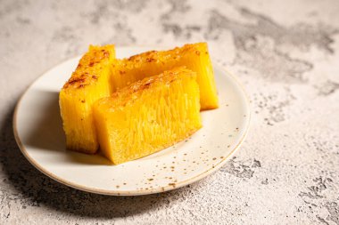 Singapur 'daki Bika ambonu veya altın kuih bingka, tapyoka unu, yumurta, şeker, maya ve hindistan cevizi sütü gibi malzemelerden yapılan Endonezya tatlısı..