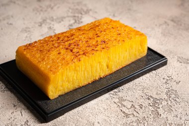 Singapur 'daki Bika ambonu veya altın kuih bingka, tapyoka unu, yumurta, şeker, maya ve hindistan cevizi sütü gibi malzemelerden yapılan Endonezya tatlısı..