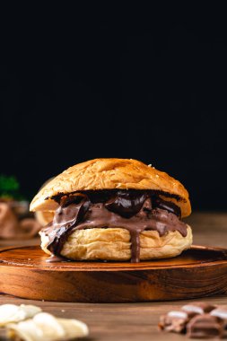 Çikolatalı dondurmalı hamburger. Ahşap arka planda dondurmalı sandviç.. 