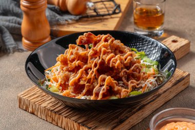 Siyah tabakta mayonez kaplı gevrek et fileto parçaları.