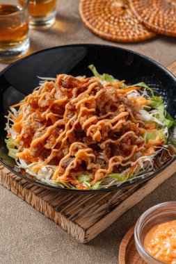 Siyah tabakta mayonez kaplı gevrek et fileto parçaları.