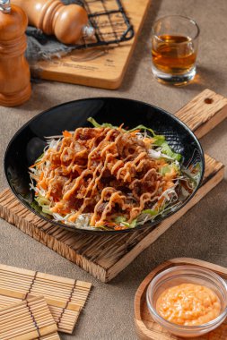 Siyah tabakta mayonez kaplı gevrek et fileto parçaları.