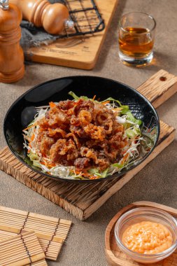 Siyah tabakta mayonez kaplı gevrek et fileto parçaları.