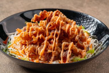 Siyah tabakta mayonez kaplı gevrek et fileto parçaları.