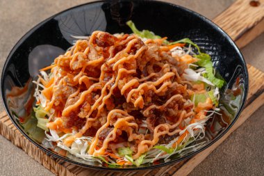 Siyah tabakta mayonez kaplı gevrek et fileto parçaları.