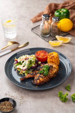 Sarımsak, soya, zencefil ve bal sosunda pişirilmiş yarım tavuk. Fırında mısır, salata ve domates tabağı.. 