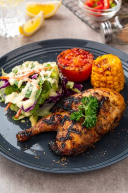 Sarımsak, soya, zencefil ve bal sosunda pişirilmiş yarım tavuk. Fırında mısır, salata ve domates tabağı.. 