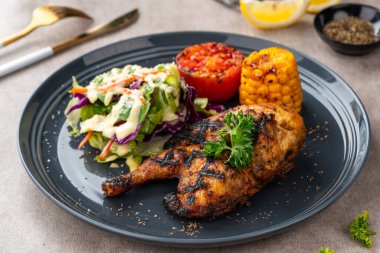 Sarımsak, soya, zencefil ve bal sosunda pişirilmiş yarım tavuk. Fırında mısır, salata ve domates tabağı.. 