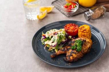 Sarımsak, soya, zencefil ve bal sosunda pişirilmiş yarım tavuk. Fırında mısır, salata ve domates tabağı.. 