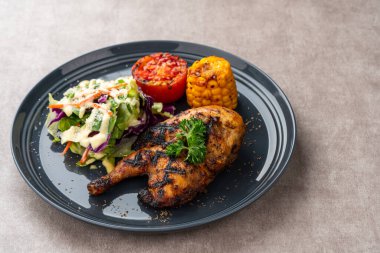 Sarımsak, soya, zencefil ve bal sosunda pişirilmiş yarım tavuk. Fırında mısır, salata ve domates tabağı.. 