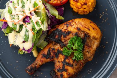 Sarımsak, soya, zencefil ve bal sosunda pişirilmiş yarım tavuk. Fırında mısır, salata ve domates tabağı.. 