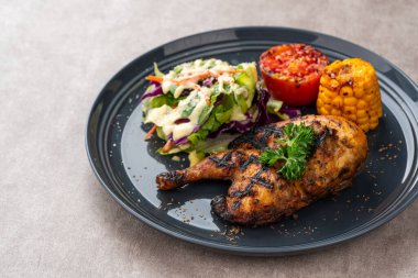 Sarımsak, soya, zencefil ve bal sosunda pişirilmiş yarım tavuk. Fırında mısır, salata ve domates tabağı.. 