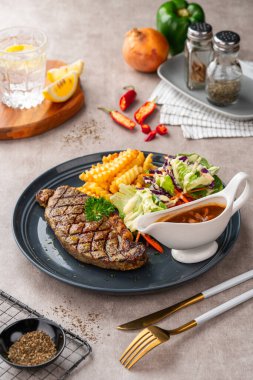 Kızarmış sığır bifteği, patates kızartması ve salata..