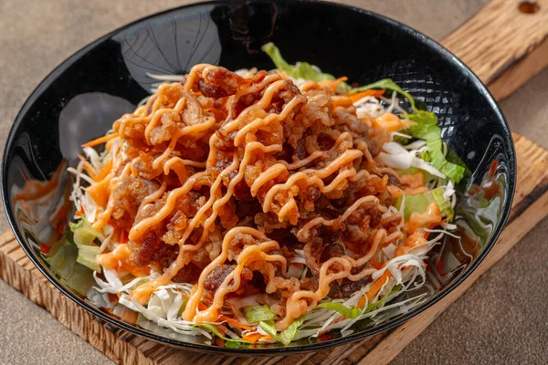 Siyah tabakta mayonez kaplı gevrek et fileto parçaları.