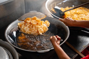 Balado 'yu boşaltma işlemi, Batı Sumatra' dan Baharatlı Atıştırmalıklar. Melinjo krakerlerinden yapılmış, çıtır çıtır, tatlı ve baharatlı..