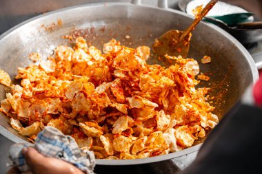 Balado 'yu boşaltma işlemi, Batı Sumatra' dan Baharatlı Atıştırmalıklar. Melinjo krakerlerinden yapılmış, çıtır çıtır, tatlı ve baharatlı..