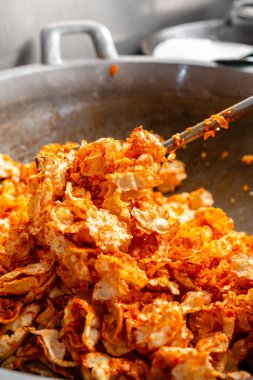 Balado 'yu boşaltma işlemi, Batı Sumatra' dan Baharatlı Atıştırmalıklar. Melinjo krakerlerinden yapılmış, çıtır çıtır, tatlı ve baharatlı..