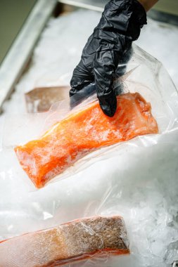 Buza yerleştirilmiş donmuş somon filetosu taze doku ve parlak turuncu rengi gösteriyor. Deniz ürünleri menüleri, sağlıklı gıda konseptleri, yemek hazırlama ve yemek malzemeleri için ideal..