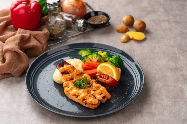 Mentai soslu ızgara somon filetosu ve siyah tabakta patates püresi..