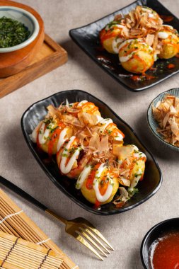 Takoyaki, buğday unlu hamurdan yapılmış ve özel bir tavada pişirilmiş top şeklinde bir Japon aperatifi.