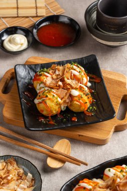 Takoyaki, buğday unlu hamurdan yapılmış ve özel bir tavada pişirilmiş top şeklinde bir Japon aperatifi.