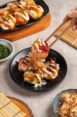 Takoyaki, buğday unlu hamurdan yapılmış ve özel bir tavada pişirilmiş top şeklinde bir Japon aperatifi.