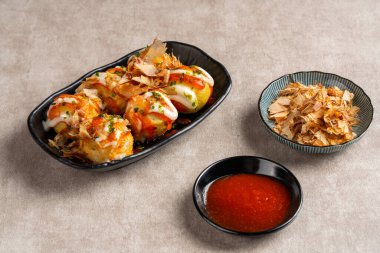 Takoyaki, buğday unlu hamurdan yapılmış ve özel bir tavada pişirilmiş top şeklinde bir Japon aperatifi.