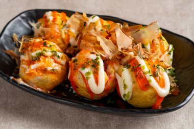 Takoyaki, buğday unlu hamurdan yapılmış ve özel bir tavada pişirilmiş top şeklinde bir Japon aperatifi.