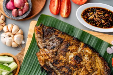 Gurame Bakar veya ızgara Gourami tepside servis edilen Endonezya baharatları ve muz yaprağı.