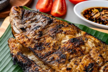 Gurame Bakar veya ızgara Gourami tepside servis edilen Endonezya baharatları ve muz yaprağı.