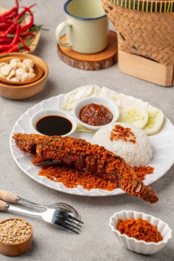 Sambal balado ile kızartılmış yayın balığı (Endonezya: lele goreng) geleneksel Endonezya mutfağı, Popüler sokak yemekleri Pecel Lele Lamongan veya Penyetan Lele 'dir..
